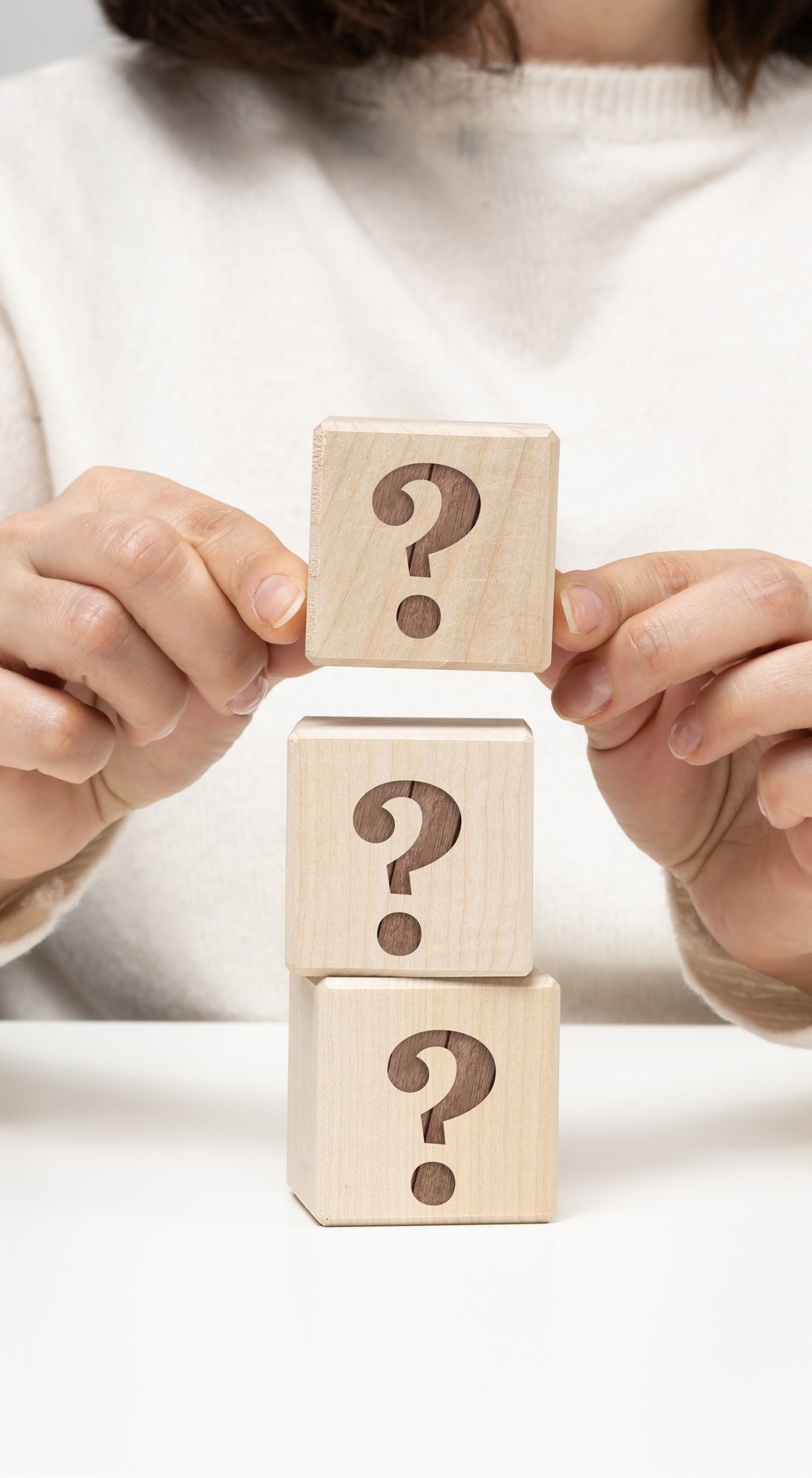 female-hand-holding-a-wooden-cube-with-a-question-2025-03-24-06-47-08-utc