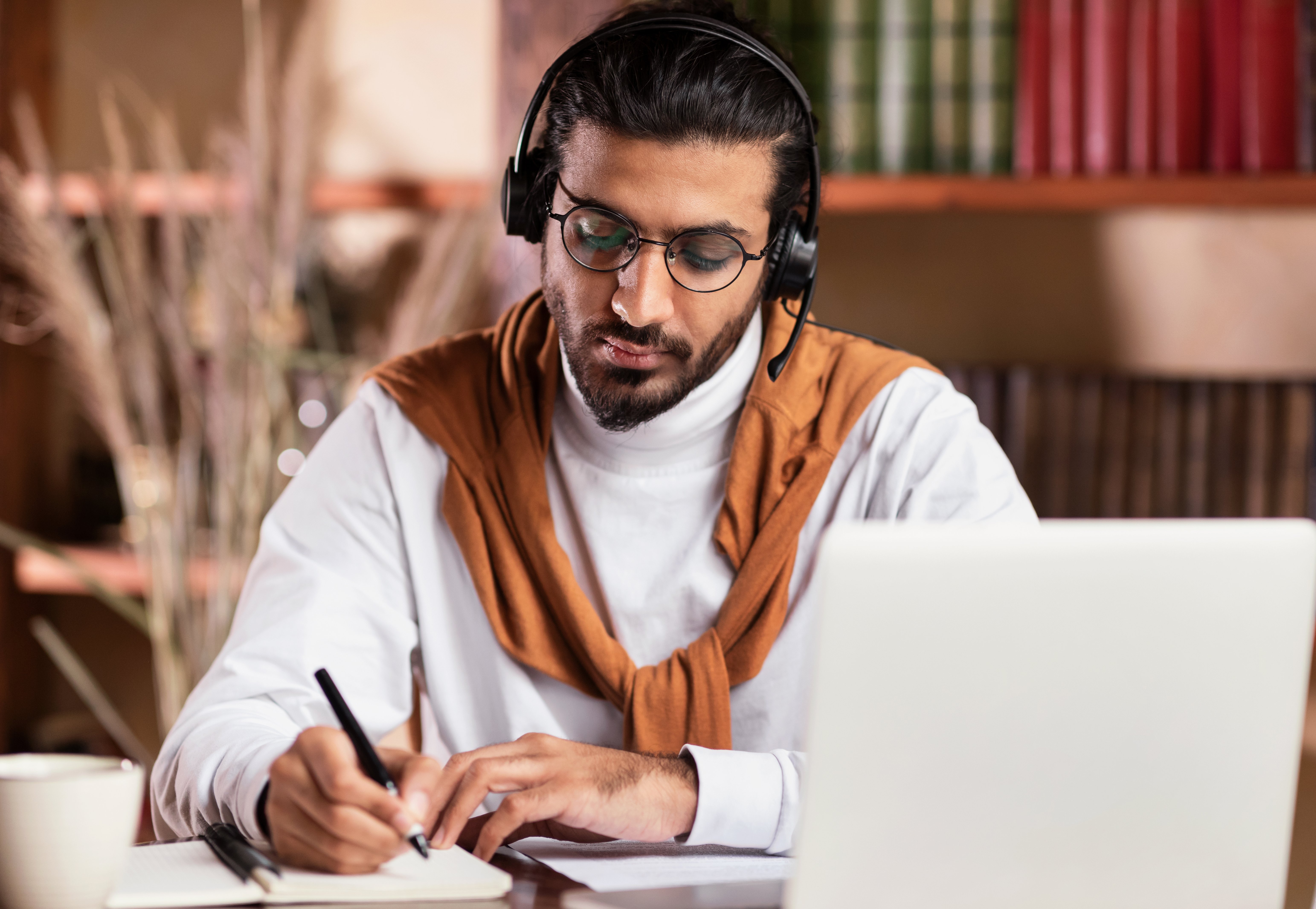 indian-guy-taking-notes-learning-at-laptop-online-2021-08-30-00-04-52-utc